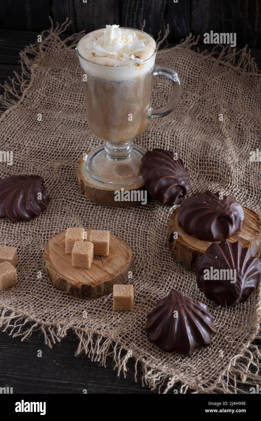 café avec lait et guimauves au chocolat et sucre de canne sur toile de fond en bois sombre, style rustique Banque D'Images