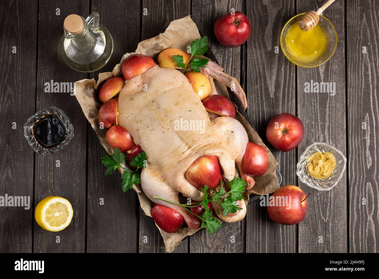 Jeunes canards entiers crus bio sur papier froissé avec sel et pommes rouges de jardinage sur fond de texture noire. Avec lindre mariné Banque D'Images