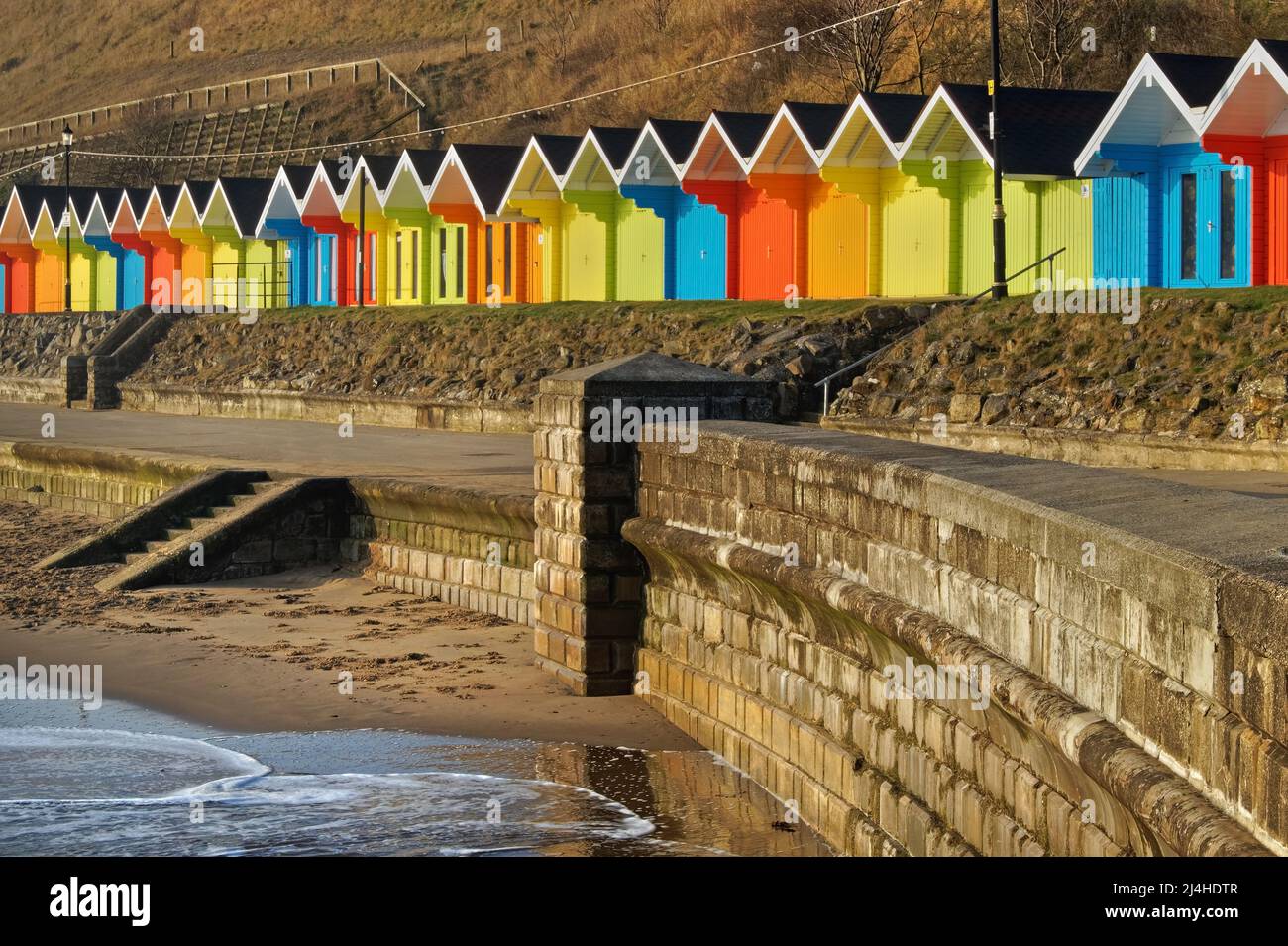 Royaume-Uni, North Yorkshire, Scarborough, Chalets de plage colorés sur North Bay Promenade. Banque D'Images