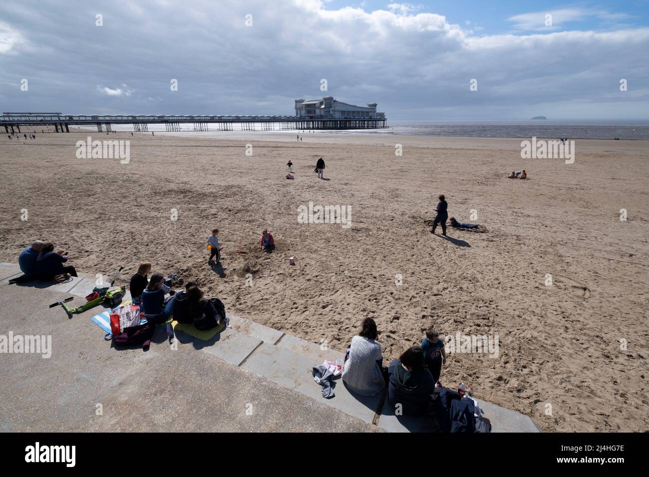Les vacanciers apprécient la plage de Weston Super Mare avec le Grand Pier dans le Bristol Chanel, Somerset. Banque D'Images