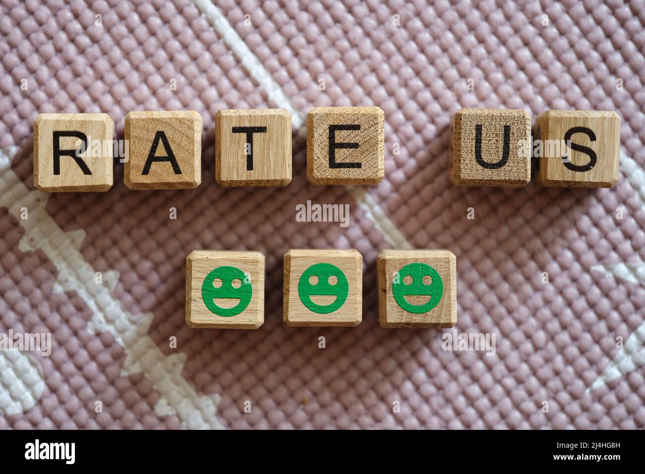 Notez-nous l'inscription sur les cubes et les émoticônes vertes souriantes Banque D'Images Notez-nous l'inscription sur les cubes et les émoticônes vertes souriantes Banque D'Images