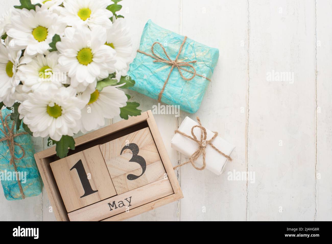 Chrysanthèmes blancs sur fond de bois avec un calendrier le 13 mai, la Journée internationale des mères Banque D'Images