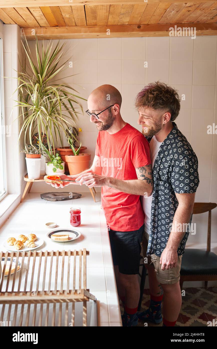 Un couple gay dans la cuisine fait le petit déjeuner Banque D'Images