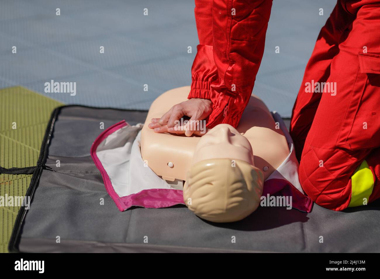 Détails avec les mains d'un travailleur des services médicaux d'urgence qui effectue une réanimation cardiopulmonaire (RCP) sur un mannequin à des fins éducatives. Banque D'Images