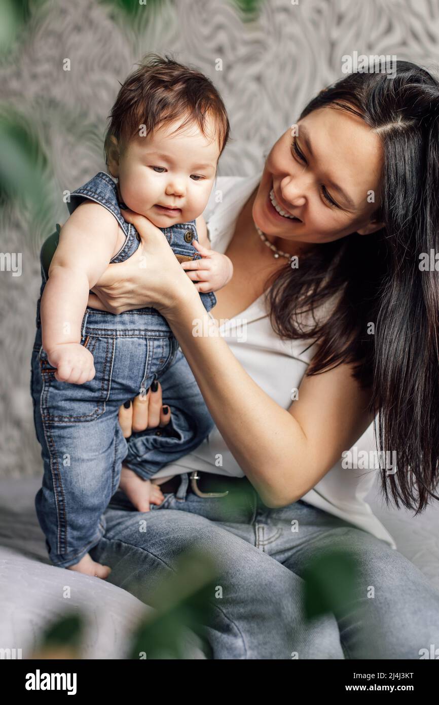 Portrait de mère heureuse avec petite fille dans la chambre à coucher gros plan, espace libre de copie, arrière-plan flou. Jouez et amusez-vous avec bébé, capturez heureux Banque D'Images