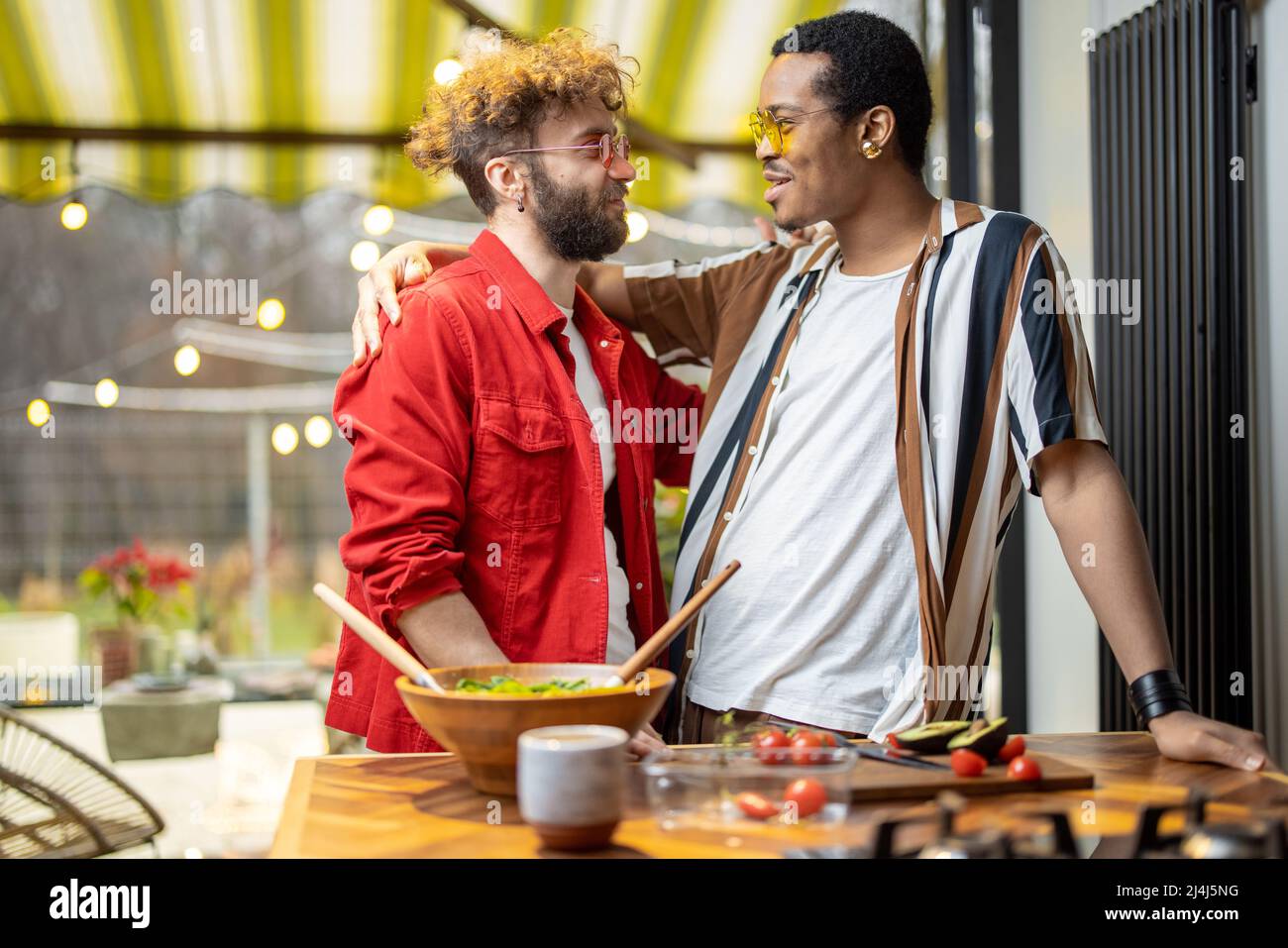 Deux gars cool qui se embrasent tout en cuisinant à la maison Banque D'Images