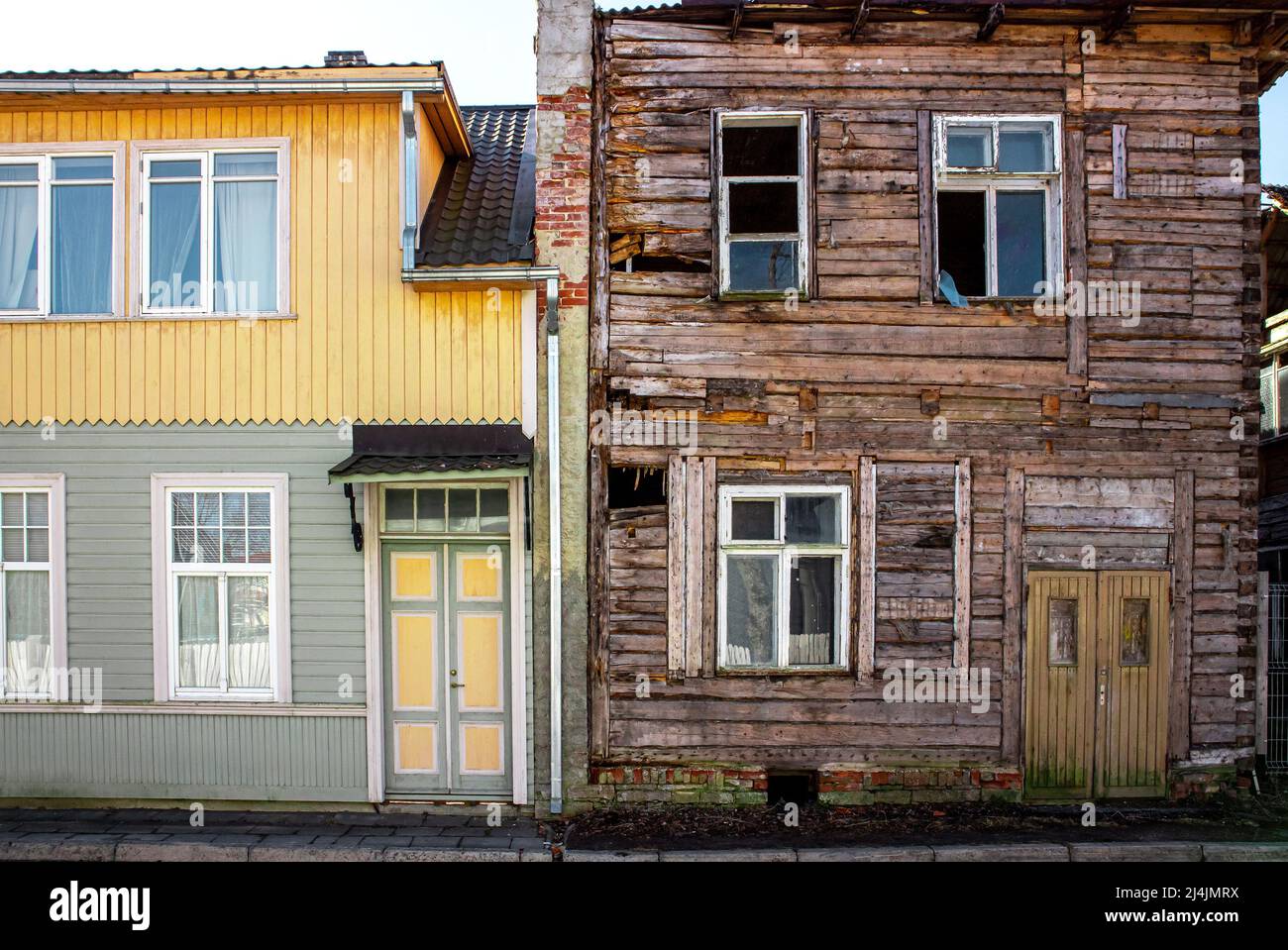 Ancien immeuble de deux étages en bois autour de 1940-1950, un côté est rénové et l'autre abandonné. Pare-feu en brique de pierre entre les appartements. Banque D'Images
