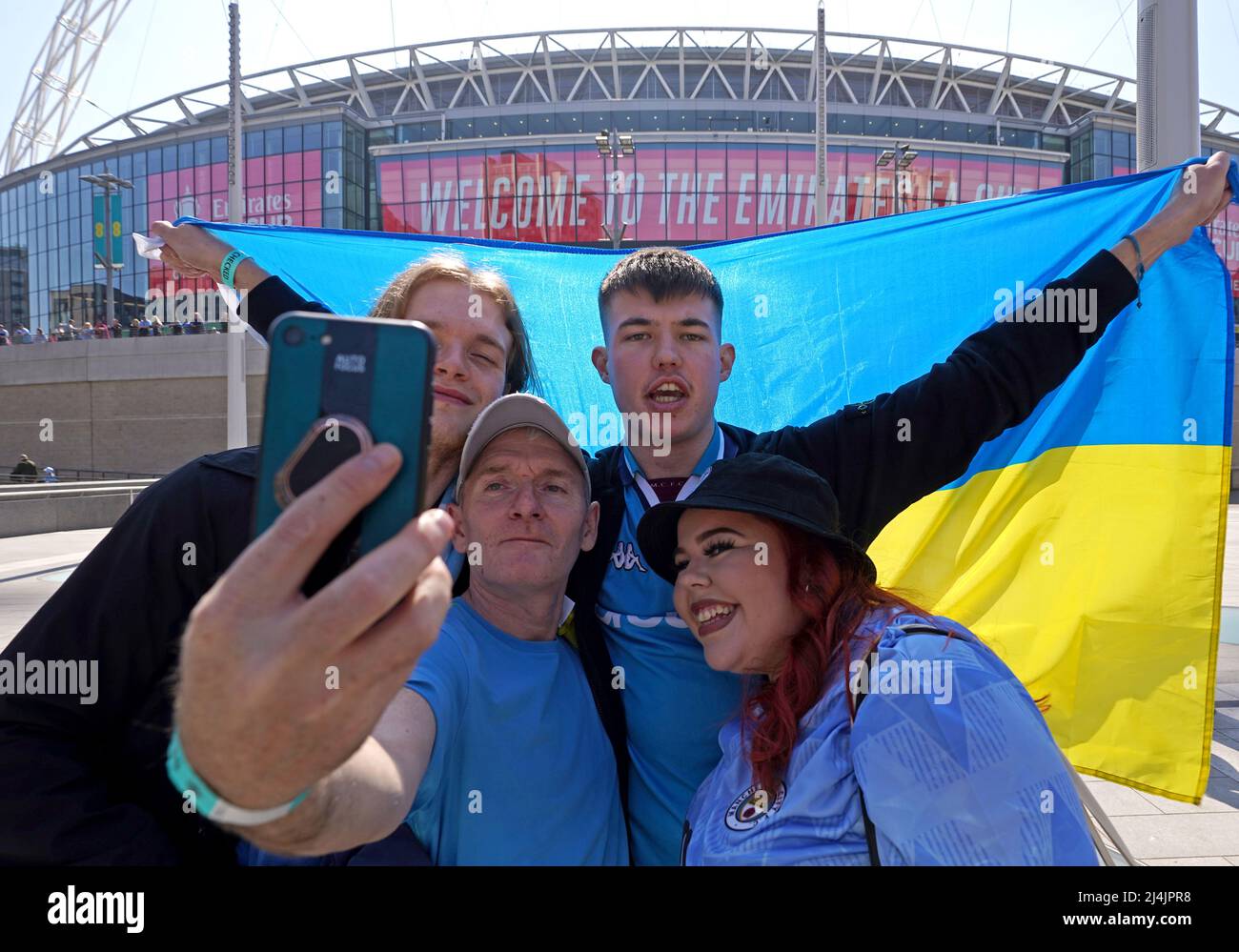 Les fans de Manchester City, dont l'un porte un drapeau ukrainien, montrent leur soutien à l'extérieur du sol avant le match de demi-finale de la coupe Emirates FA au stade Wembley, à Londres. Date de la photo: Samedi 16 avril 2022. Banque D'Images