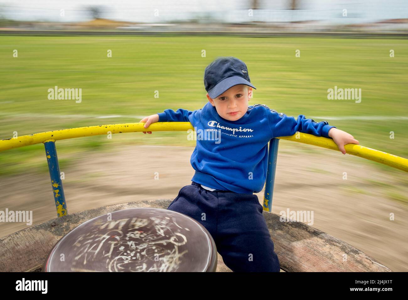 Un petit garçon mignon qui s'amuse sur le disque du terrain de jeu Banque D'Images