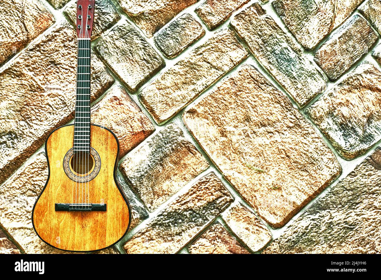Guitare acoustique jaune sur fond or pavé.espace de copie. Banque D'Images