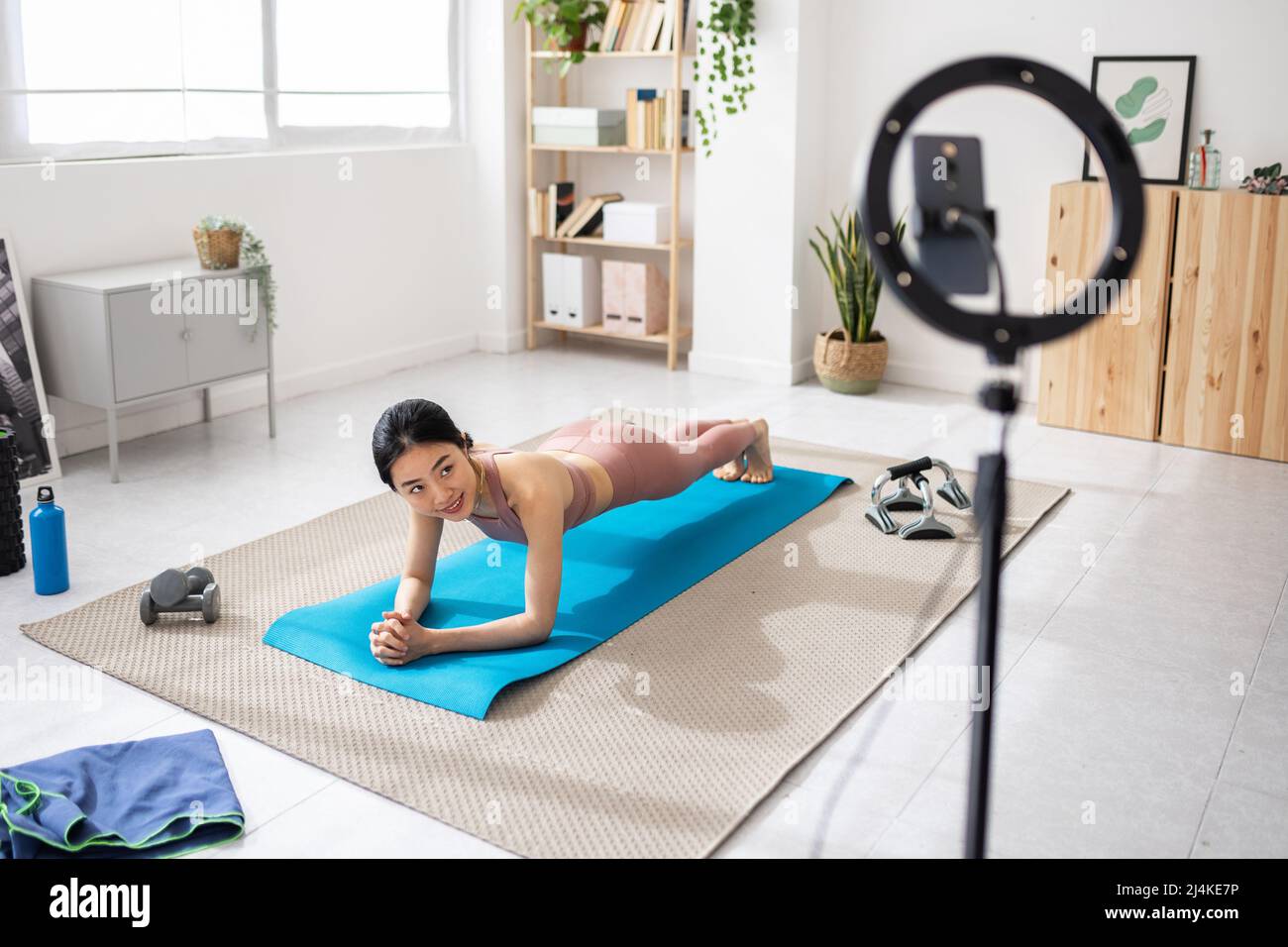Jeune femme entraîneur de forme physique menant un cours de forme physique en ligne de la maison. Banque D'Images