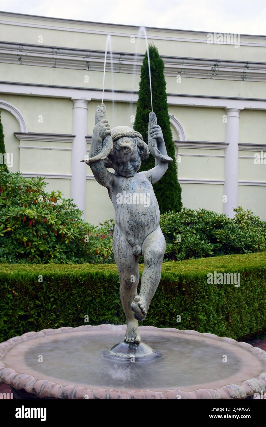 Sculpture d'une fontaine sous forme d'un garçon tenant des cornes dans ses  mains d'où coule des jets d'eau Photo Stock - Alamy