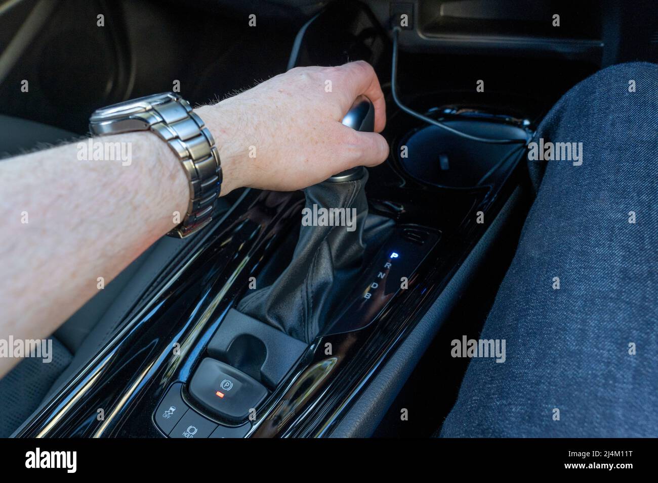 Main du conducteur maintenant le levier de changement de vitesse automatique dans un véhicule à conduite à droite en position de stationnement dans une Toyota CH-R. hybride essence à charge automatique ROYAUME-UNI Banque D'Images