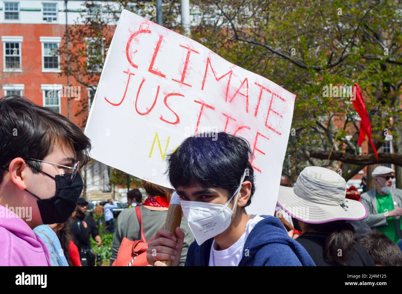 Le 16 avril 2022, un jeune homme tient un panneau pour Climate Justice à Washington Square Park, à New York. Banque D'Images
