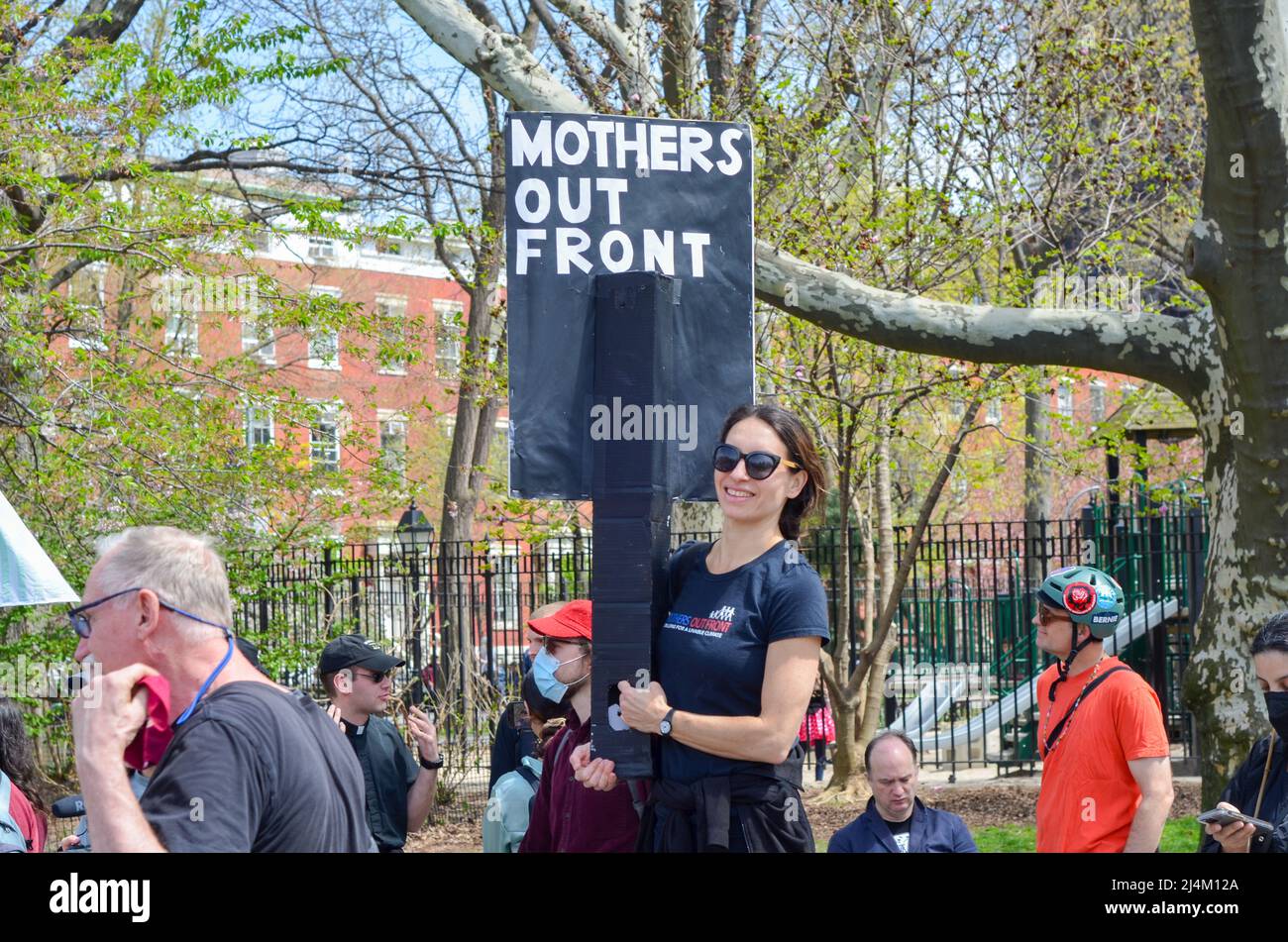 Le 16 avril 2022, un jeune homme tient un panneau pour Climate Justice à Washington Square Park, à New York. Banque D'Images