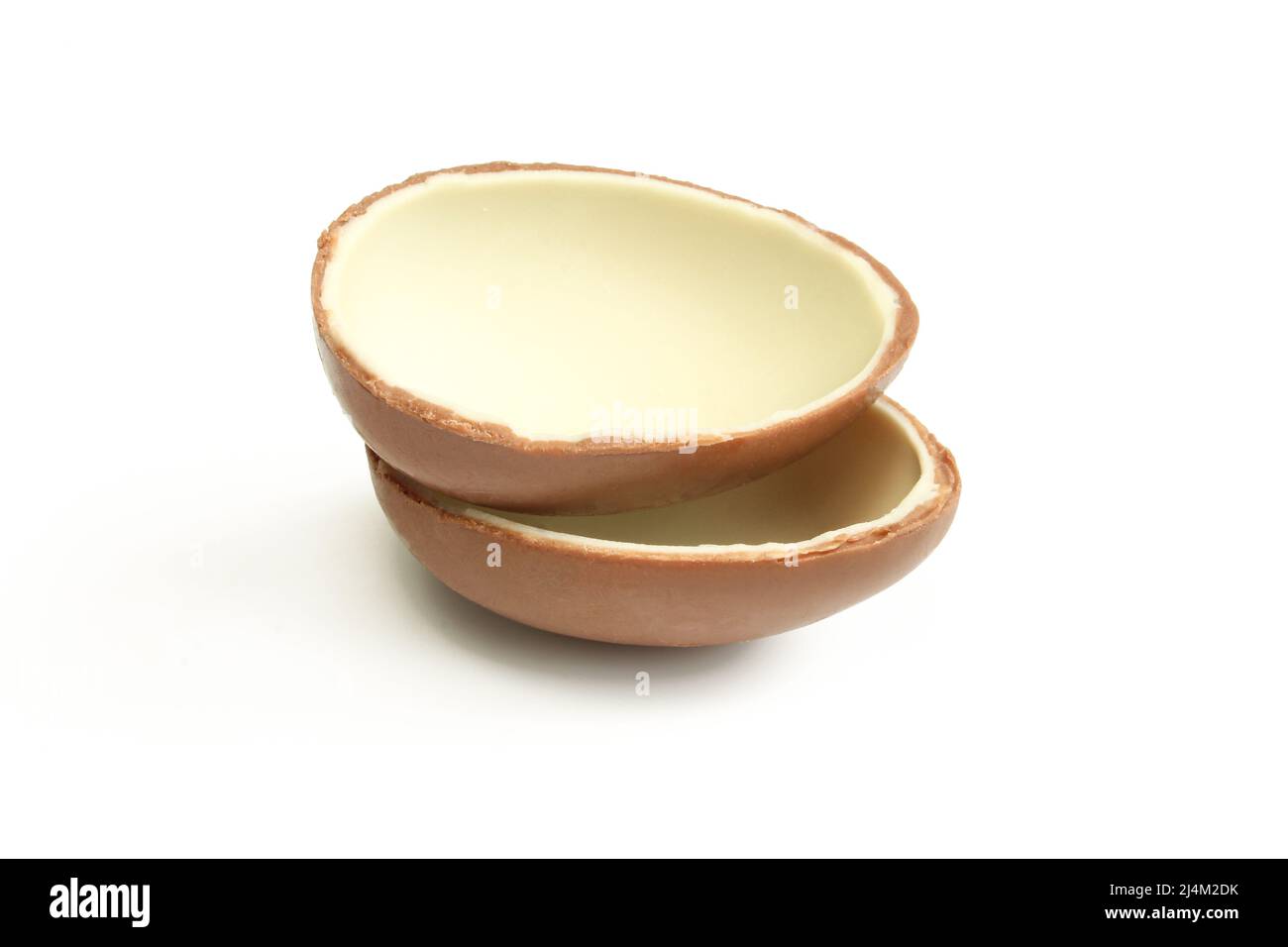 Deux moitiés d'œuf de chocolat au lait isolées sur fond blanc. Banque D'Images
