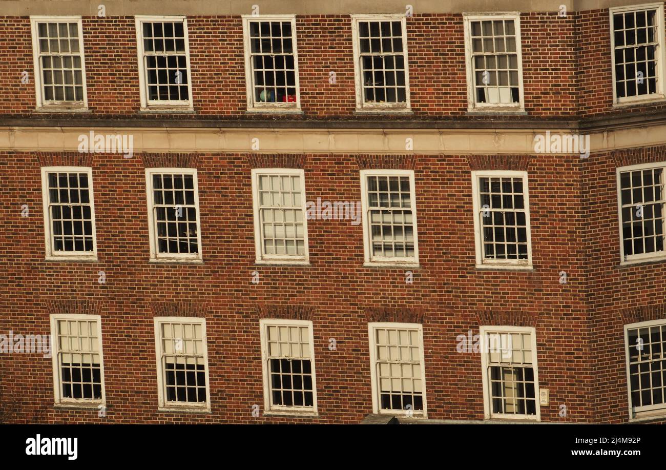 Une vue d'une fenêtre de huitième étage donnant sur un vieux bâtiment de bureau en brique avec de vieilles fenêtres en bois à guillotine à Kingston upon Thames, Londres Banque D'Images