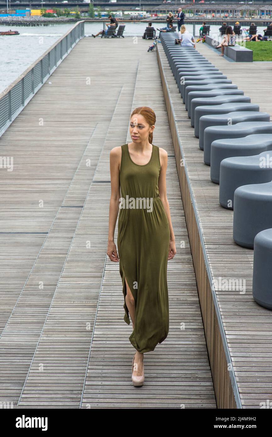 Habillée d'une robe longue verte, une jeune fille noire marche avec charme  sur les marches d'un parc Photo Stock - Alamy
