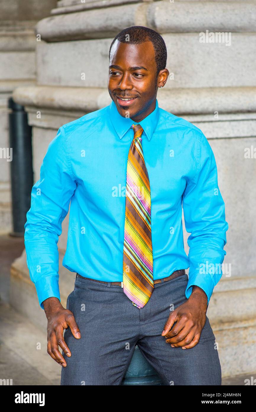 Avec sa chemise bleu clair, sa cravate à motif coloré, un jeune homme  d'affaires noir souriant s'assoit dehors pour faire une pause Photo Stock -  Alamy