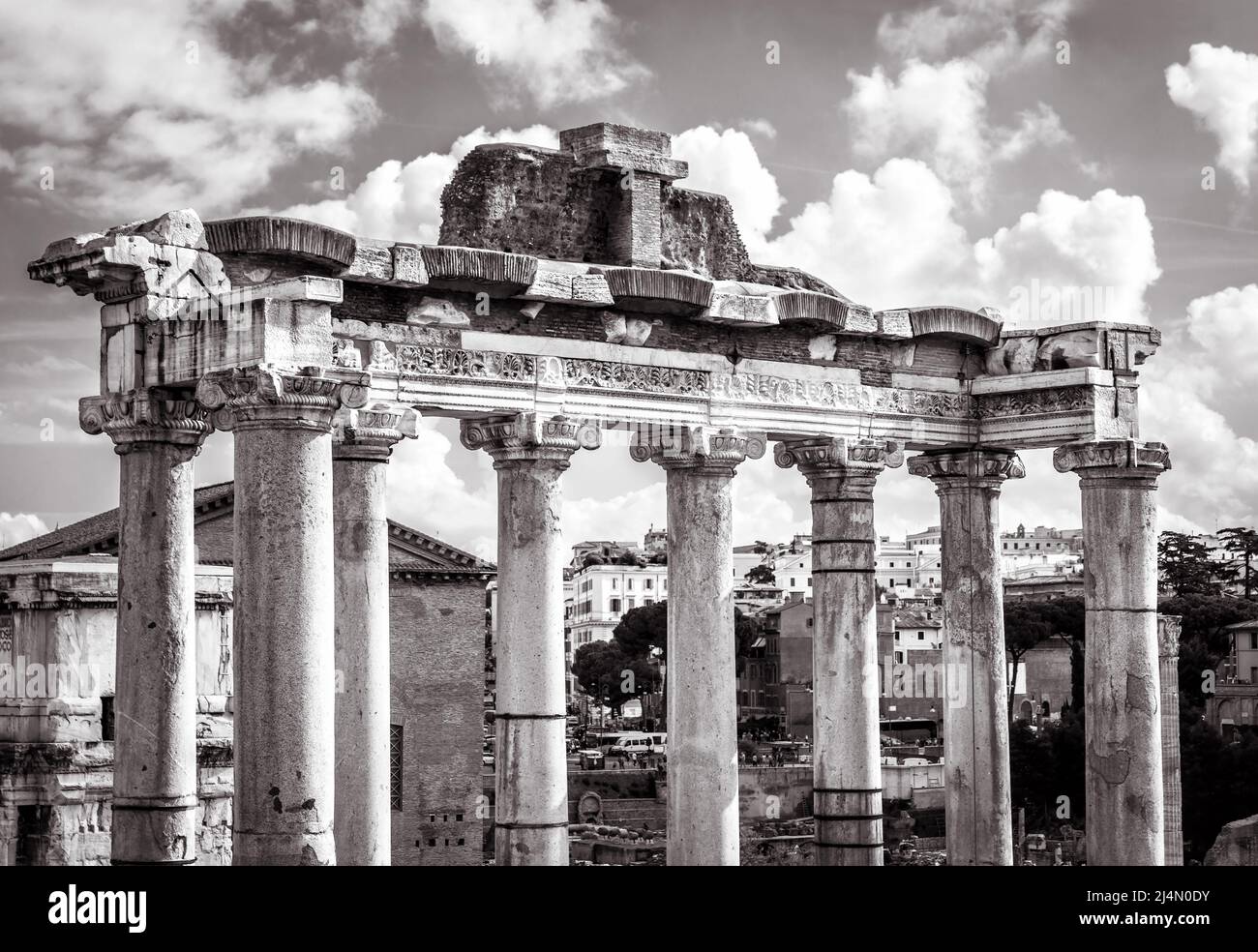 Ancien temple de Saturne dans le Forum romain, Rome, Italie. C'est un point de repère de Rome. De vieilles colonnes géantes s'élèvent sur les ruines du Forum dans le centre-ville de Roma, noir et W. Banque D'Images