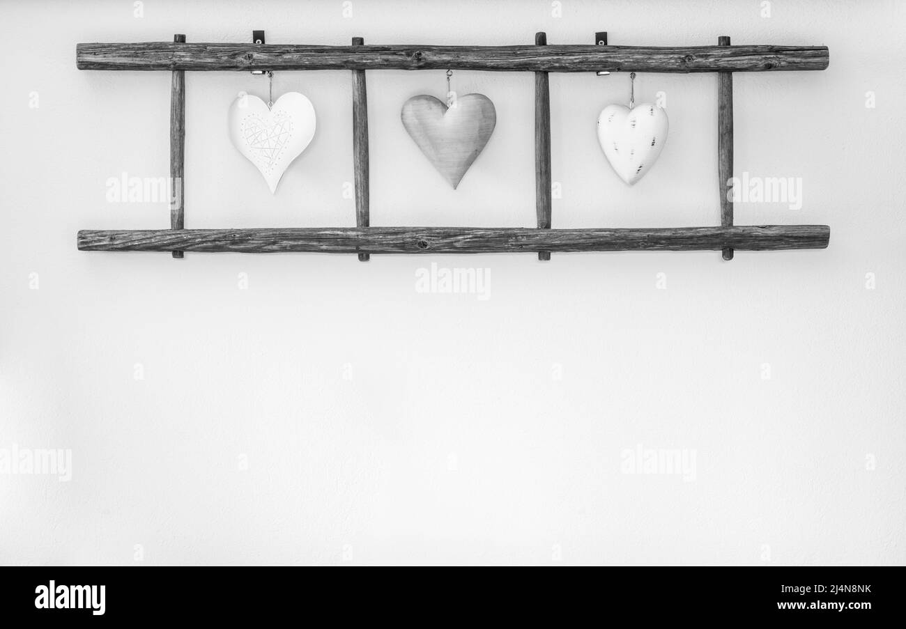 Ancienne échelle en bois avec coeurs accrochés au mur. Décoration d'intérieur. Banque D'Images