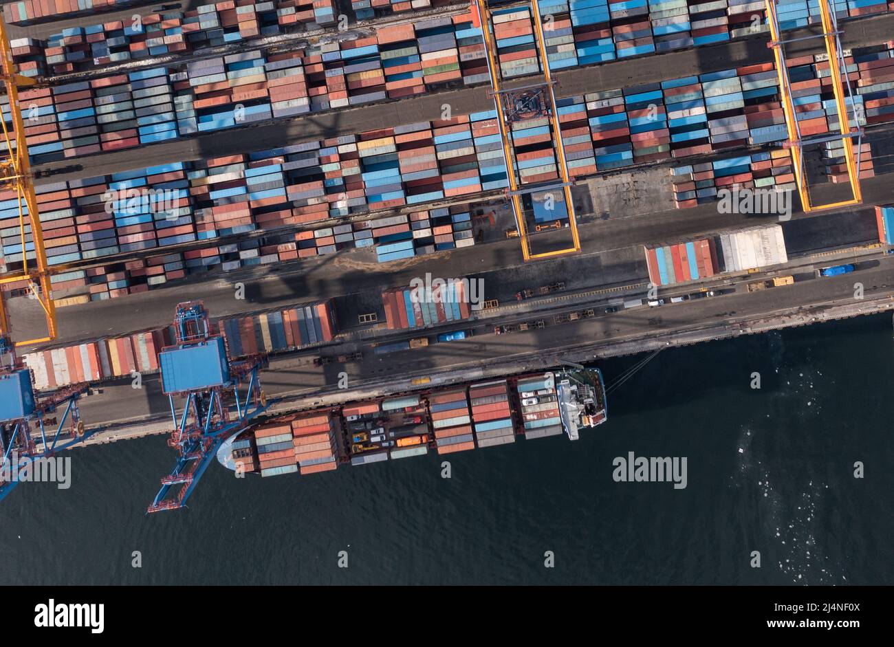 Vladivostok, Russie - 28 janvier 2022 : Vue de dessus du terminal des conteneurs du port maritime. En hiver, un bateau à conteneurs est en train de charger au quai. Banque D'Images
