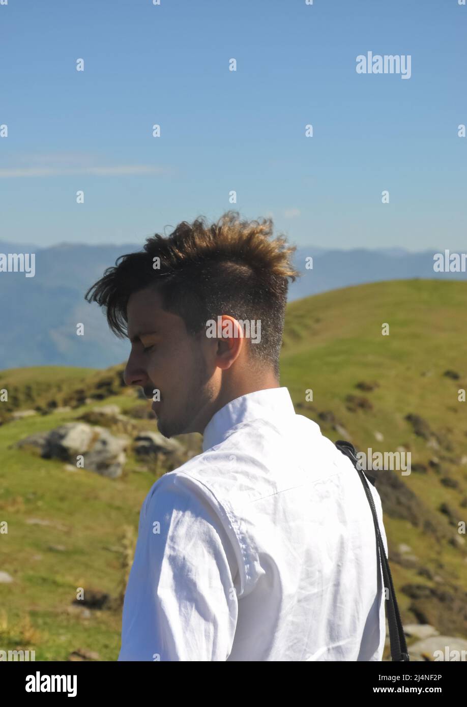 Vue arrière d'un jeune homme beau debout dans la nature avec les yeux fermés Banque D'Images