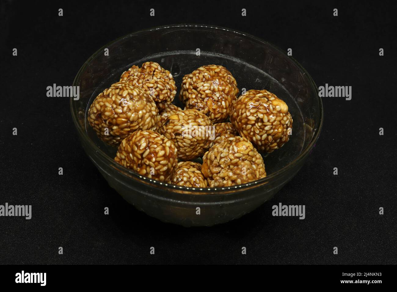 Les boules de sésame sont dans une tasse. Sur fond noir Banque D'Images