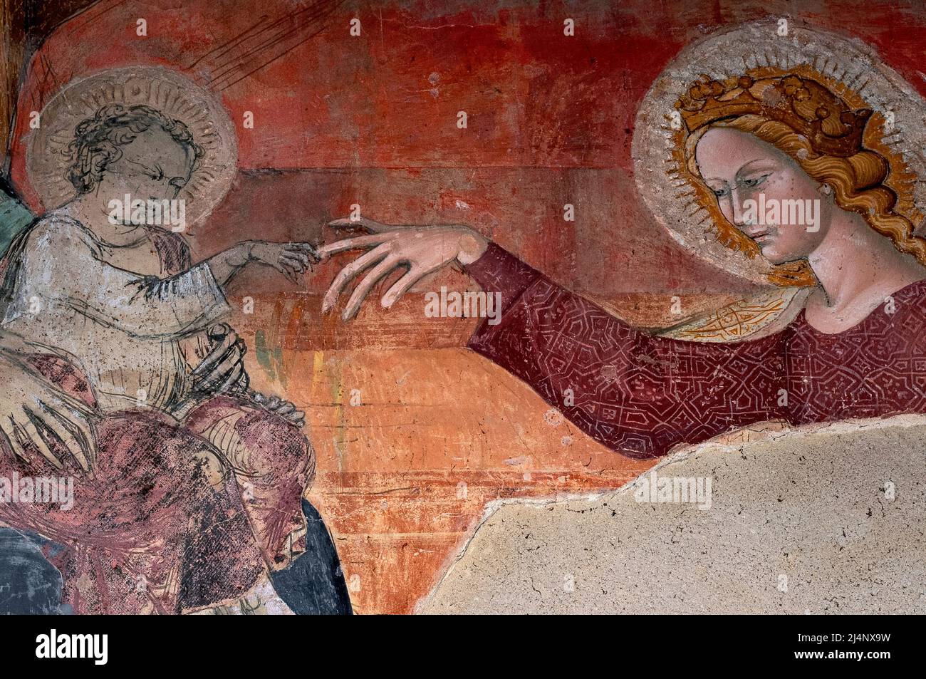 Toucher le bout des doigts de l'enfant Christ. Détail de la fresque italienne endommagée, peinte vers 1410, dans la Chiesa di San Domenico à Arezzo, Toscane, Italie. La peinture est attribuée à l'artiste local Giovanni d'Agnolo di Balduccio (1370-1452). Banque D'Images