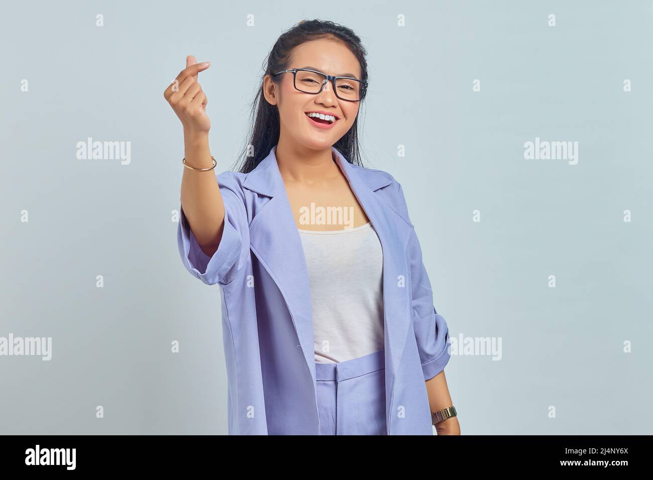 Portrait d'une jeune femme asiatique souriante montrant le cœur coréen avec deux doigts croisés, exprimer la joie et la positivité isolées sur fond blanc Banque D'Images