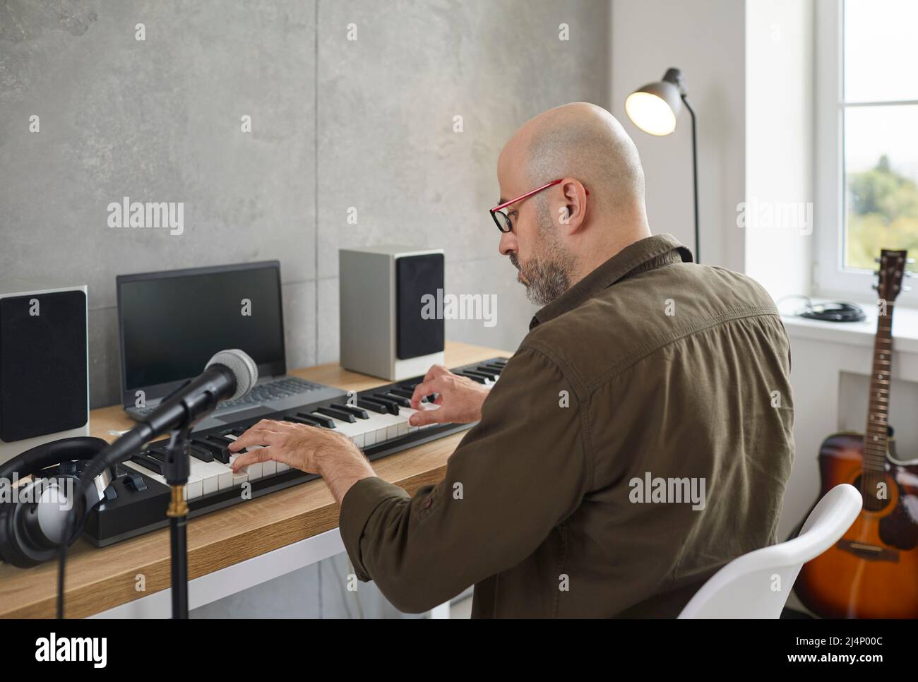 Un musicien de sexe masculin joue de la musique électronique en studio Banque D'Images