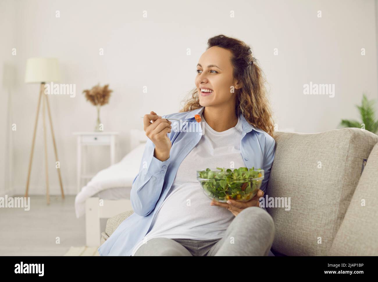 La femme enceinte qui mange de nombreux légumes différents pendant la grossesse aime la salade verte fraîche à la maison. Banque D'Images