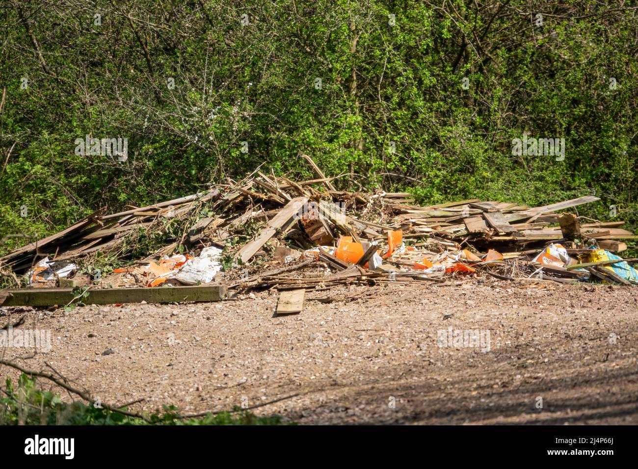 les déchets illégaux de renflement de panneaux de clôture, de gravats et de béton déposés sur une voie de campagne Banque D'Images