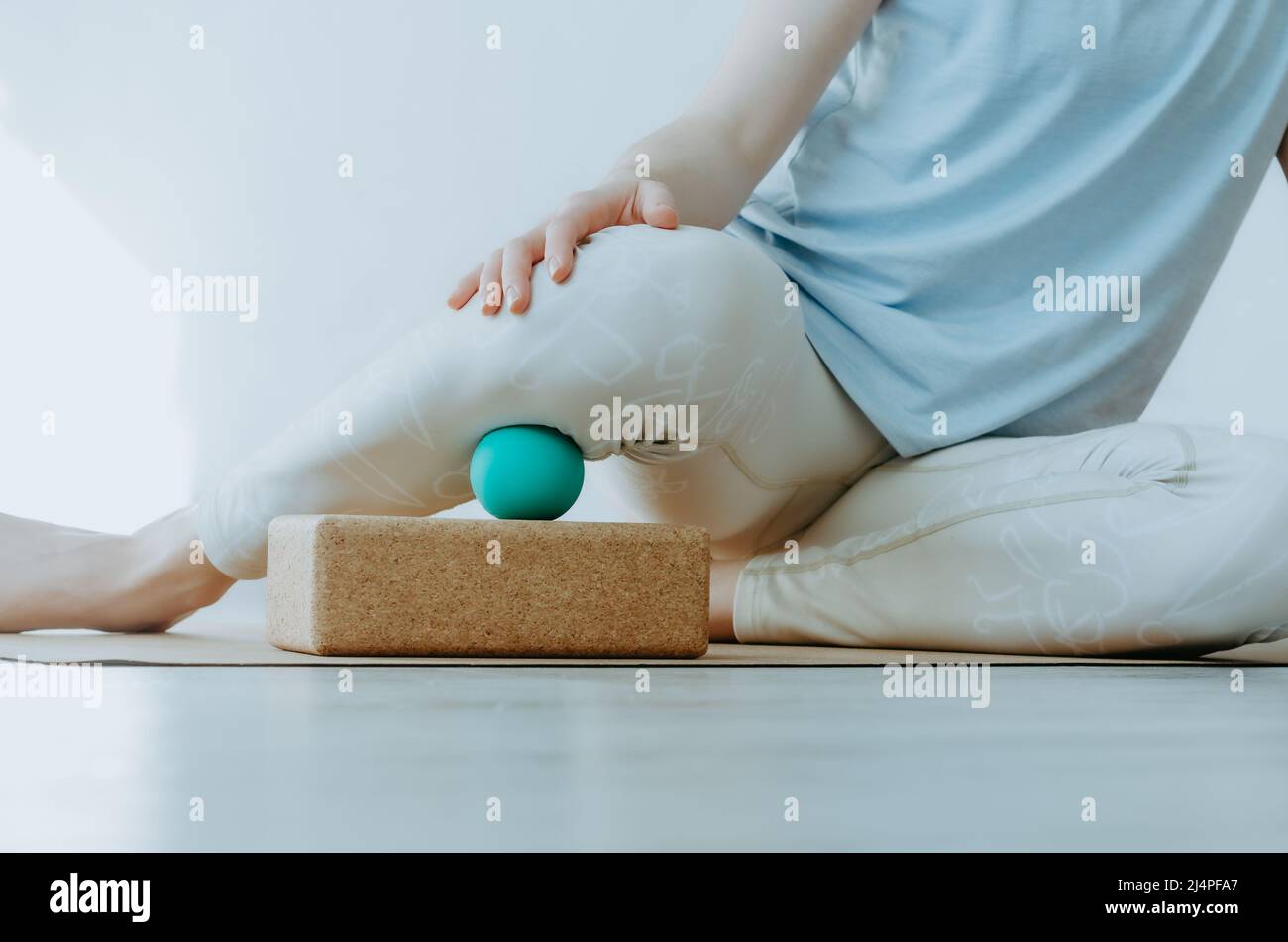 Gros plan d'une personne qui effectue une libération myofasciale avec une balle de massage sur la partie inférieure de la jambe. Concept : santé du genou, pratiques d'autosoins à domicile Banque D'Images