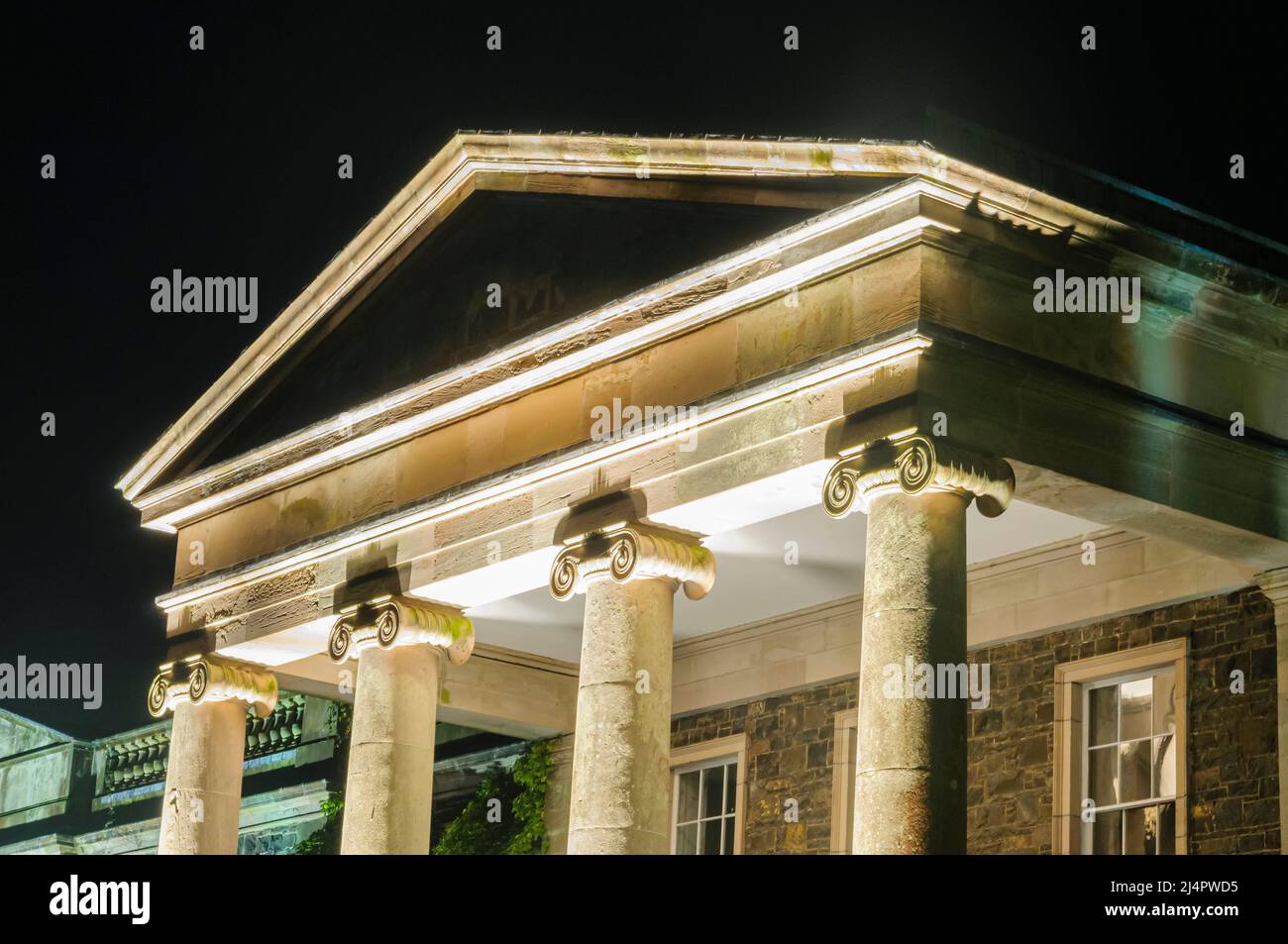 Les colonnes ioniques d'une ancienne demeure seigneuriale, illuminé par la lumière artificielle la nuit Banque D'Images