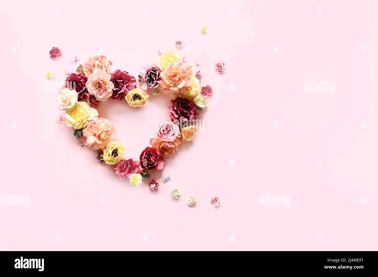 Bonne fête des mères et des Valentines. Bouquet de roses assorties colorées en forme de coeur sur fond rose et papillon. Concept de vacances Banque D'Images