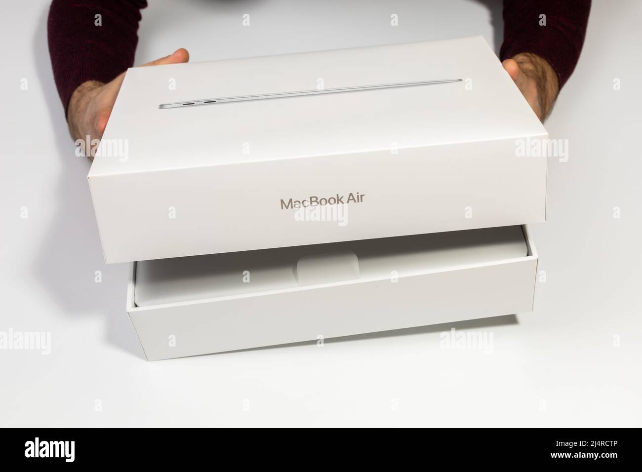 Saratov, Russie - 26 février 2022 : ouverture de l'emballage du nouveau MacBook Air 13 pouces moderne avec processeur M1, déballage de topview, fond blanc Banque D'Images