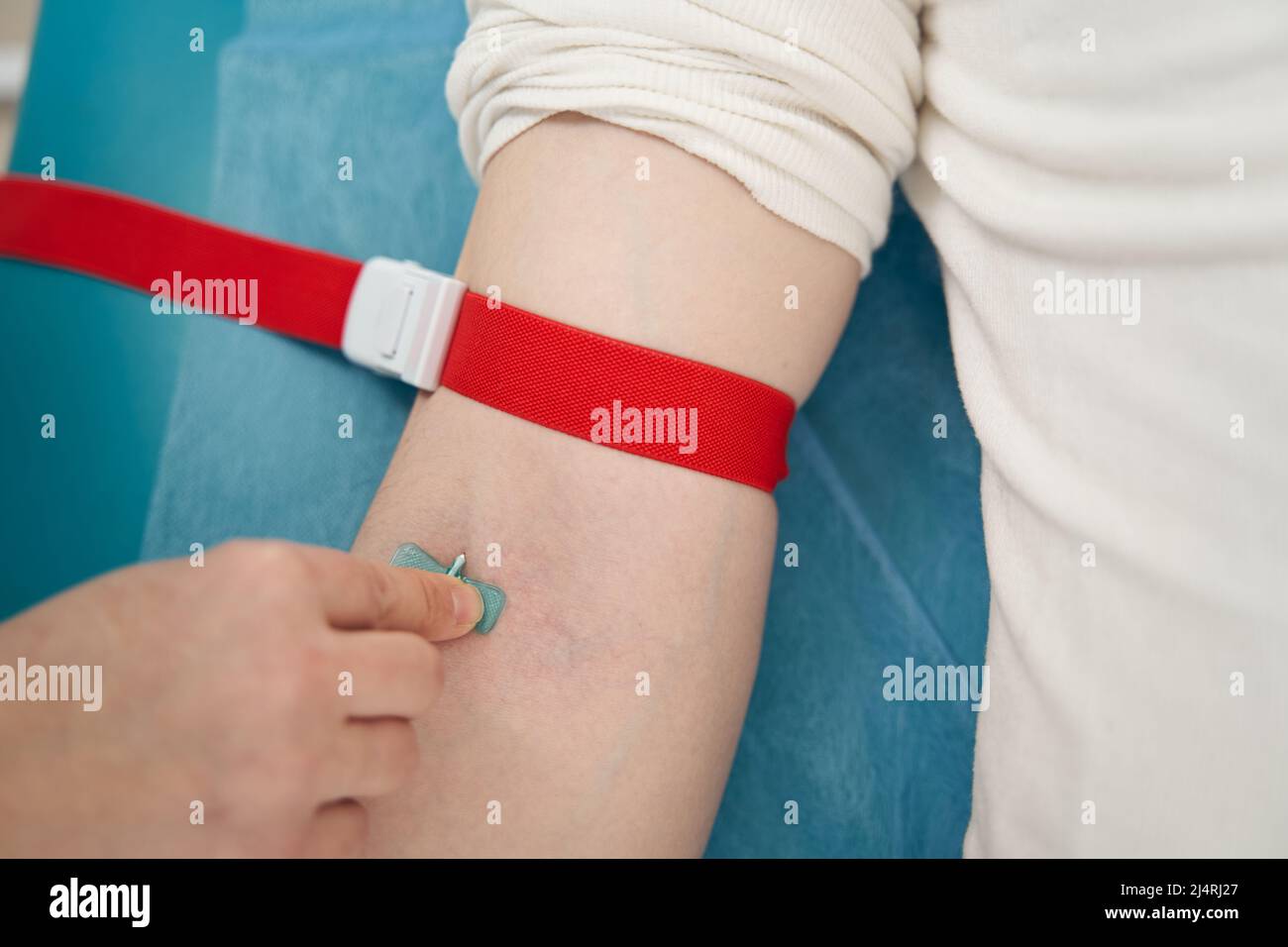L'infirmière fixe le cathéter sur le bras du patient à l'hôpital Photo
