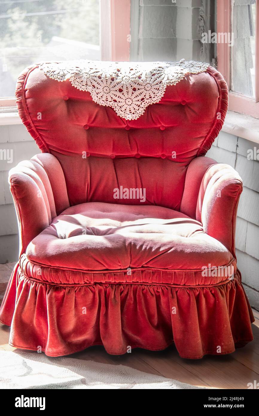 chaise berçante en velours rose vintage touffeté avec volants assis dans le coin de la pièce. Banque D'Images