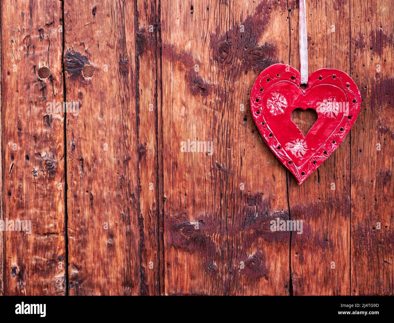 La Punt, Suisse - 29 septembre 2021 : coeur rouge décoratif accroché à un mur en bois Banque D'Images
