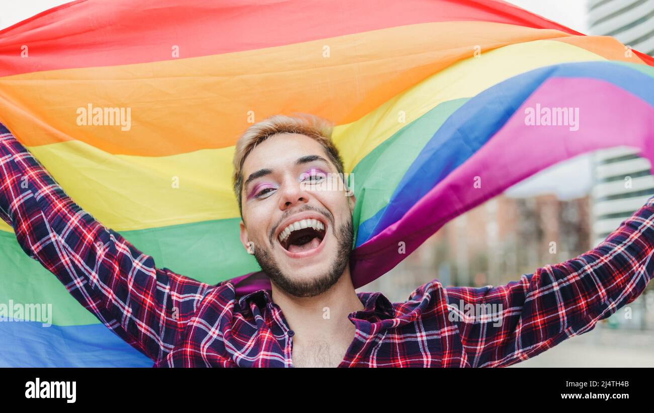 Homme gay avec maquillage sur le drapeau arc-en-ciel extérieur - LGBTQ Drag queen concept Banque D'Images