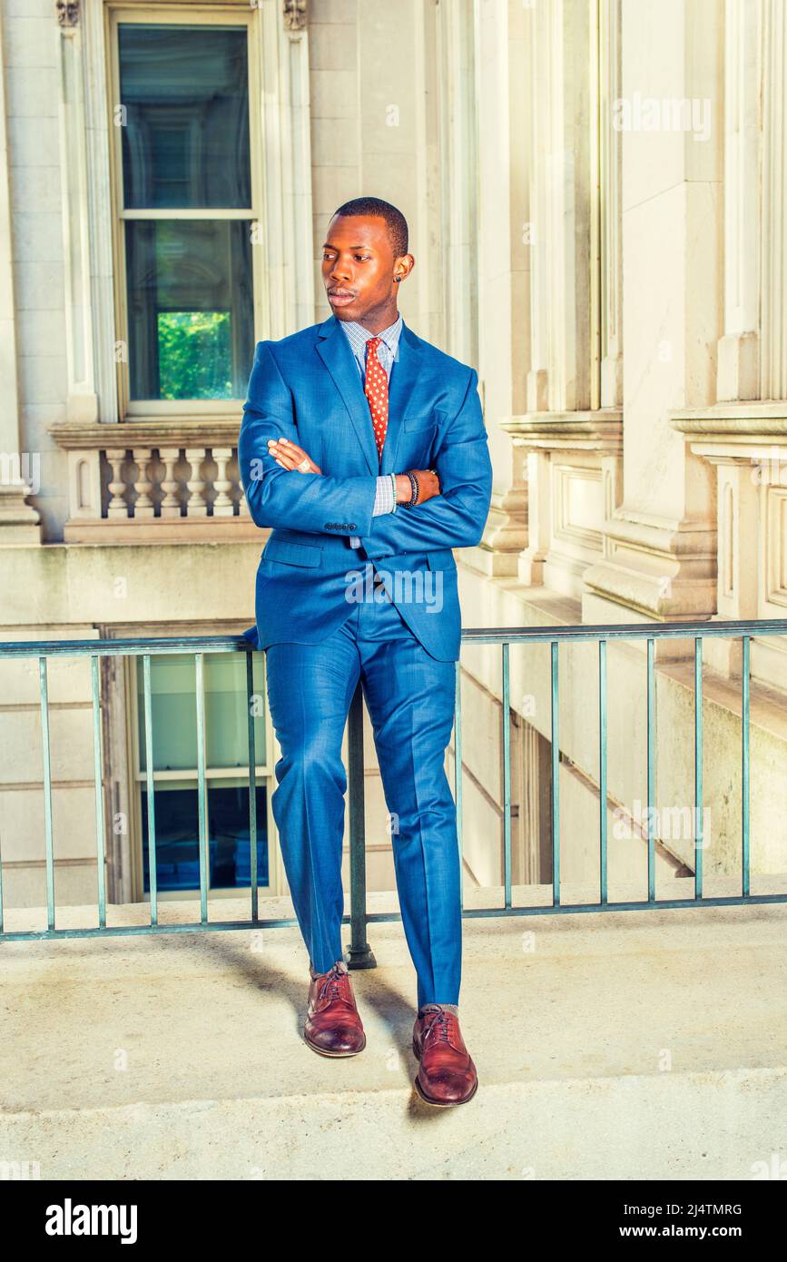 Homme qui vous attend. Robe officiellement en costume bleu, sous-chemise à  motifs, cravate, chaussures en cuir, coupe courte, croisant les armes, un  jeune homme d'affaires noir Photo Stock - Alamy