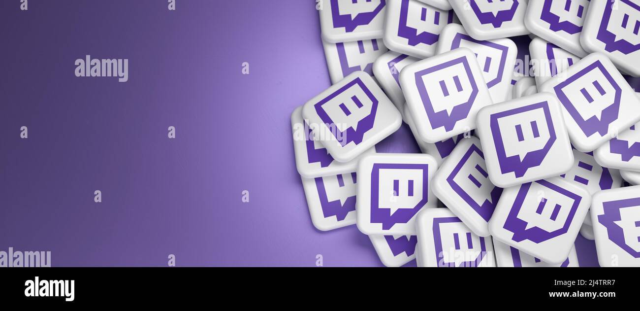 Logos de la société de service de streaming vidéo en direct et de la plate-forme Twitch (filiale d'Amazon) sur un tas sur une table. Copier l'espace. Format de bannière Web. Banque D'Images