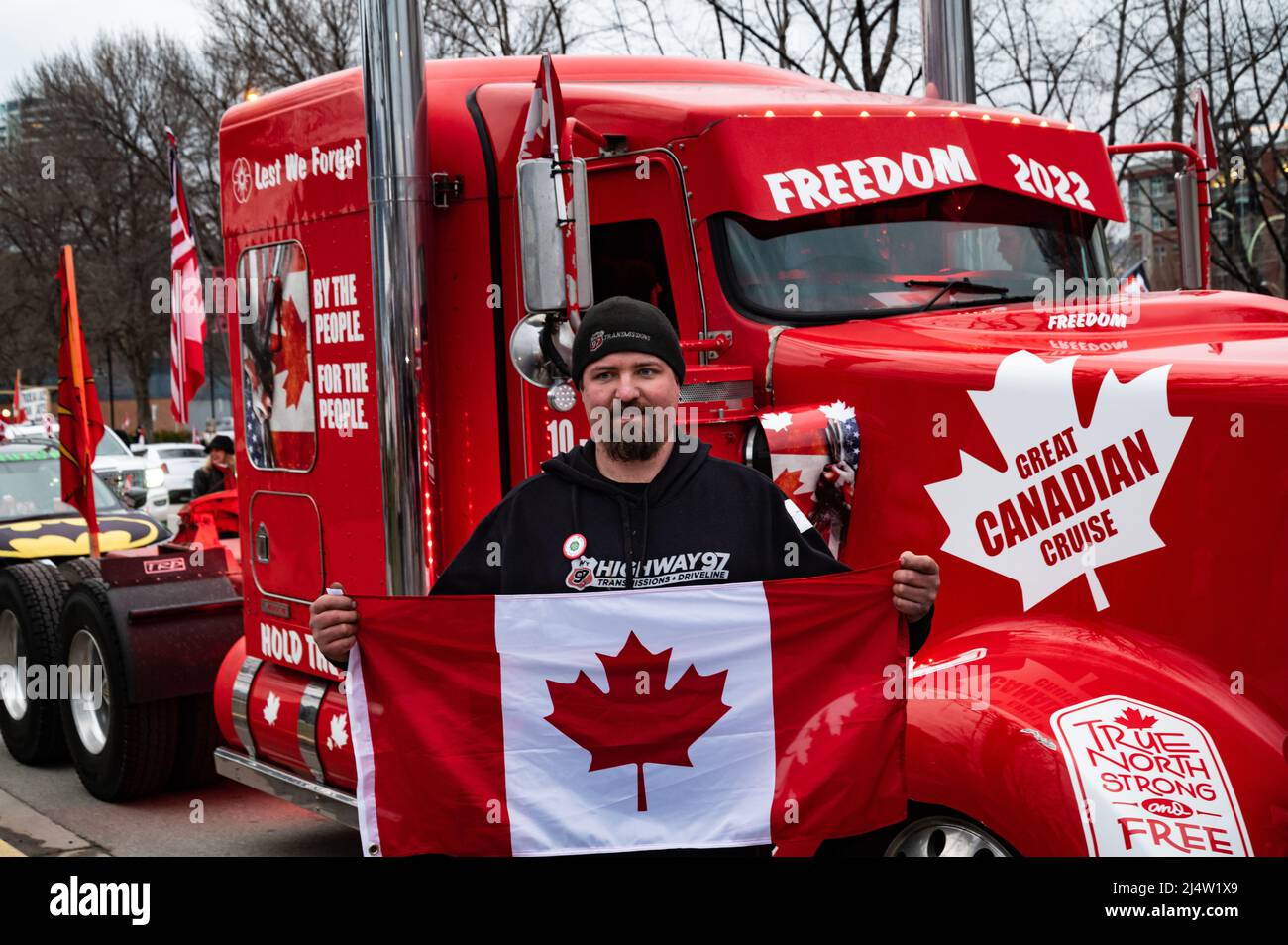 Un chauffeur de camion faisant partie de la Great Canadian Cruise détient un drapeau lors d'un événement pour protester contre les mandats du pays en matière de vaccins et d'autres restrictions de la COVID. Banque D'Images