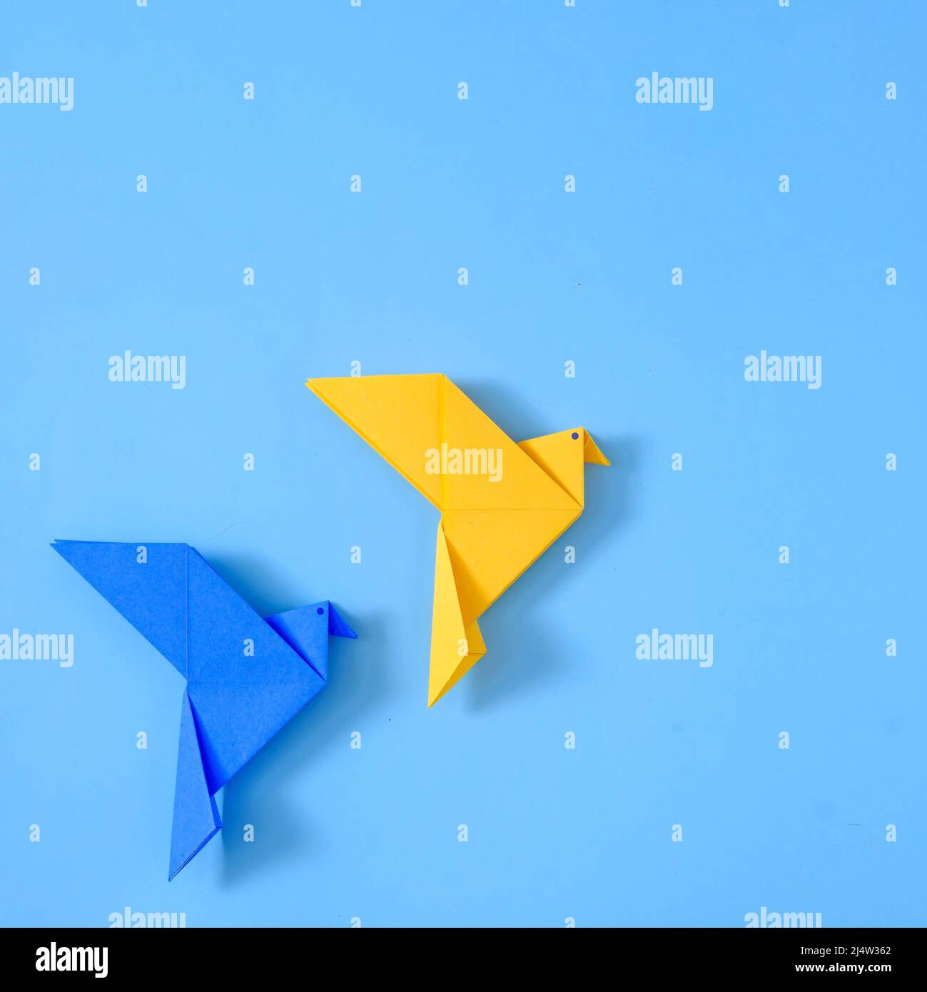 Deux colombes de paix sur fond bleu d'un jouet géométrique polygonal origami jouet fait main. Banque D'Images