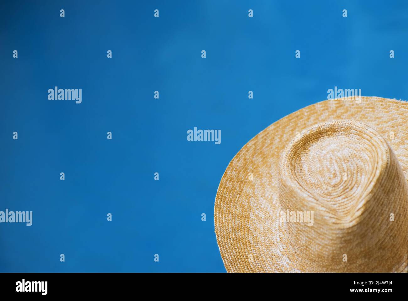 Chapeau de paille en face de fond de l'eau bleue Banque D'Images