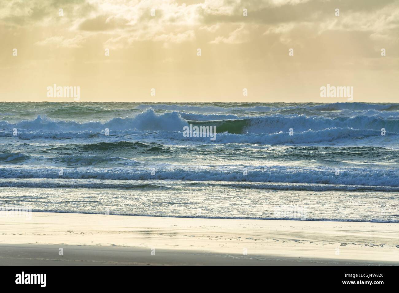 Tôt le matin, sur 75 Mile Beach, avec des rayons de lumière qui traversent les nuages pour une scène surréaliste. Fraser Island, Queensland, Australie. Banque D'Images