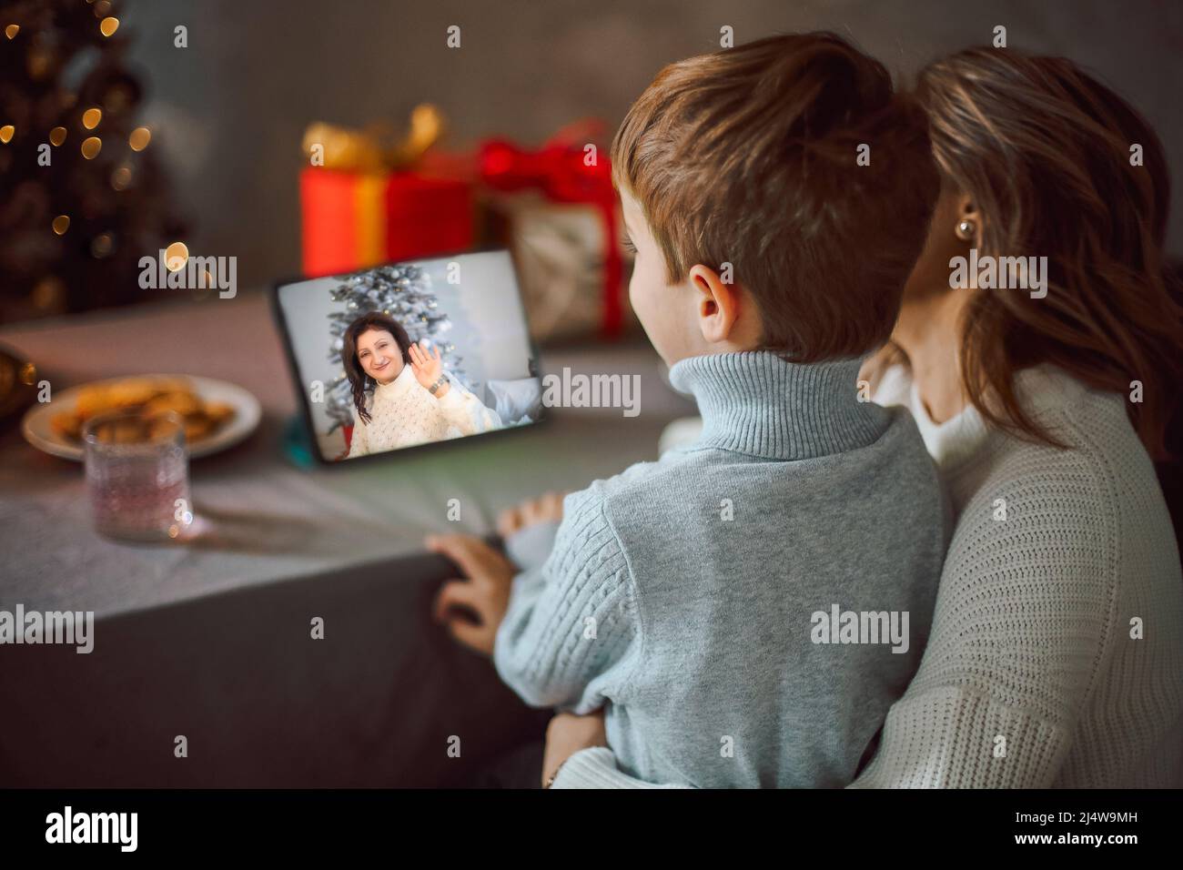 Jeune femme heureuse avec petit fils, parlant avec des amis sur le zoom virtuel appel vidéo, célébrant la fête du nouvel an en vacances à distance de conférence en ligne cha Banque D'Images