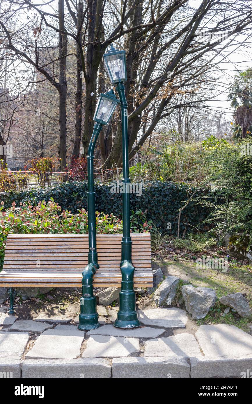 Turin, Italie - 19 mars 2022 : banc dans le Parc du Valentino avec sculpture représentant deux lampadaires amoureux. Banque D'Images