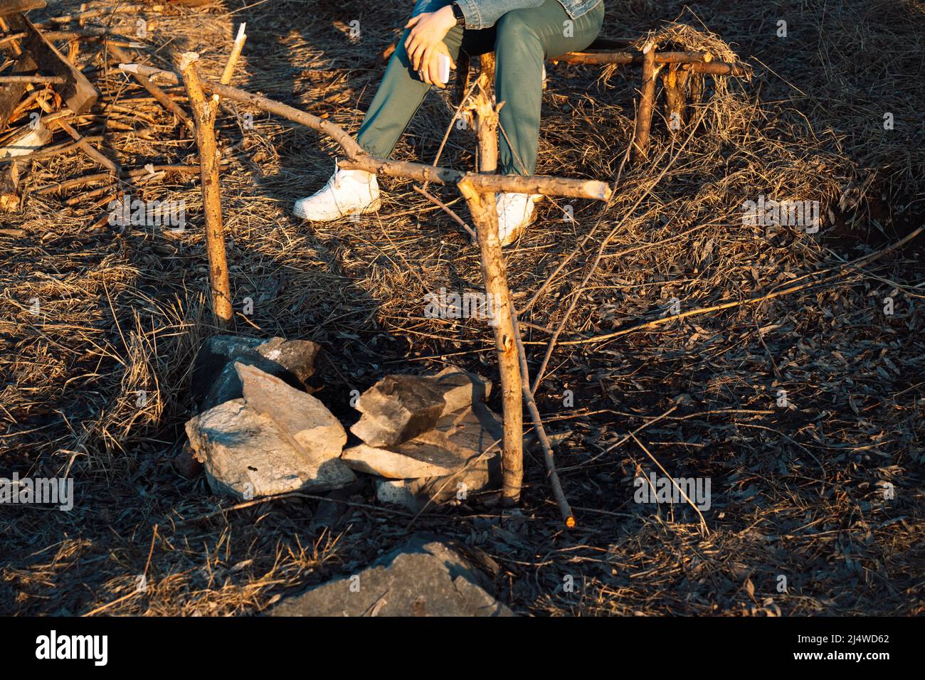 La fille se repose à l'extérieur devant le feu Banque D'Images